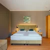 Aufenthalt im Lodenwirt direkt buchen Modernes Hotelzimmer mit Doppelbett, Nachttischen und Holzschrank