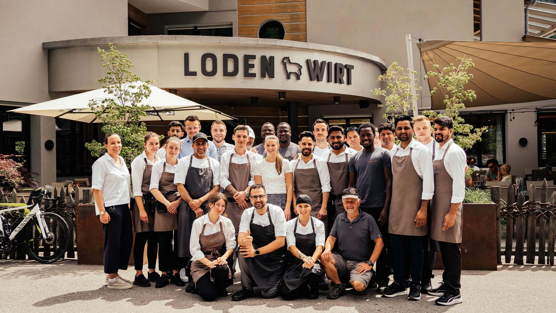 Foto di gruppo del personale del ristorante davanti all'edificio Lodenwirt