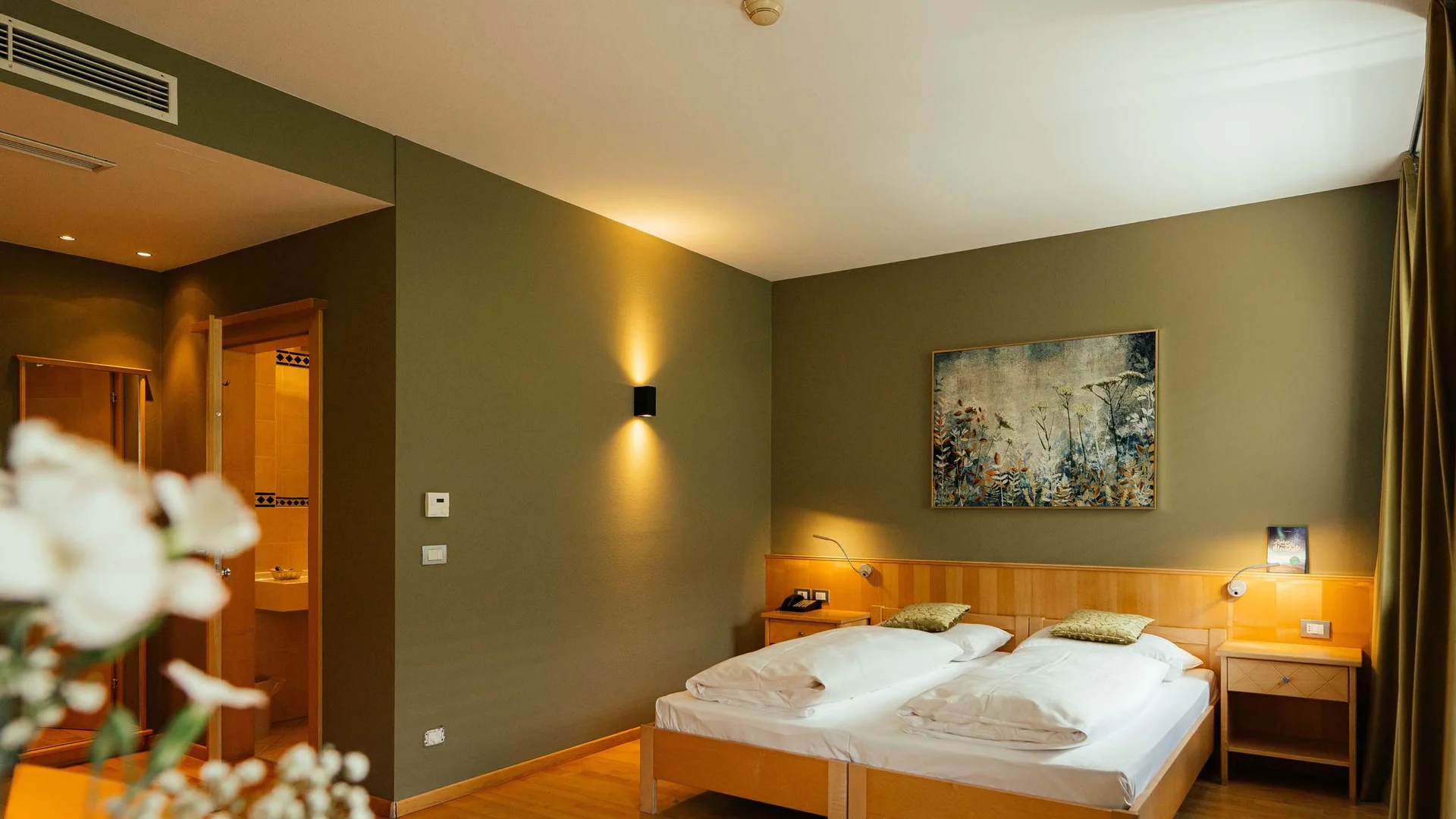 Camera d'hotel accogliente con due letti singoli e luce calda