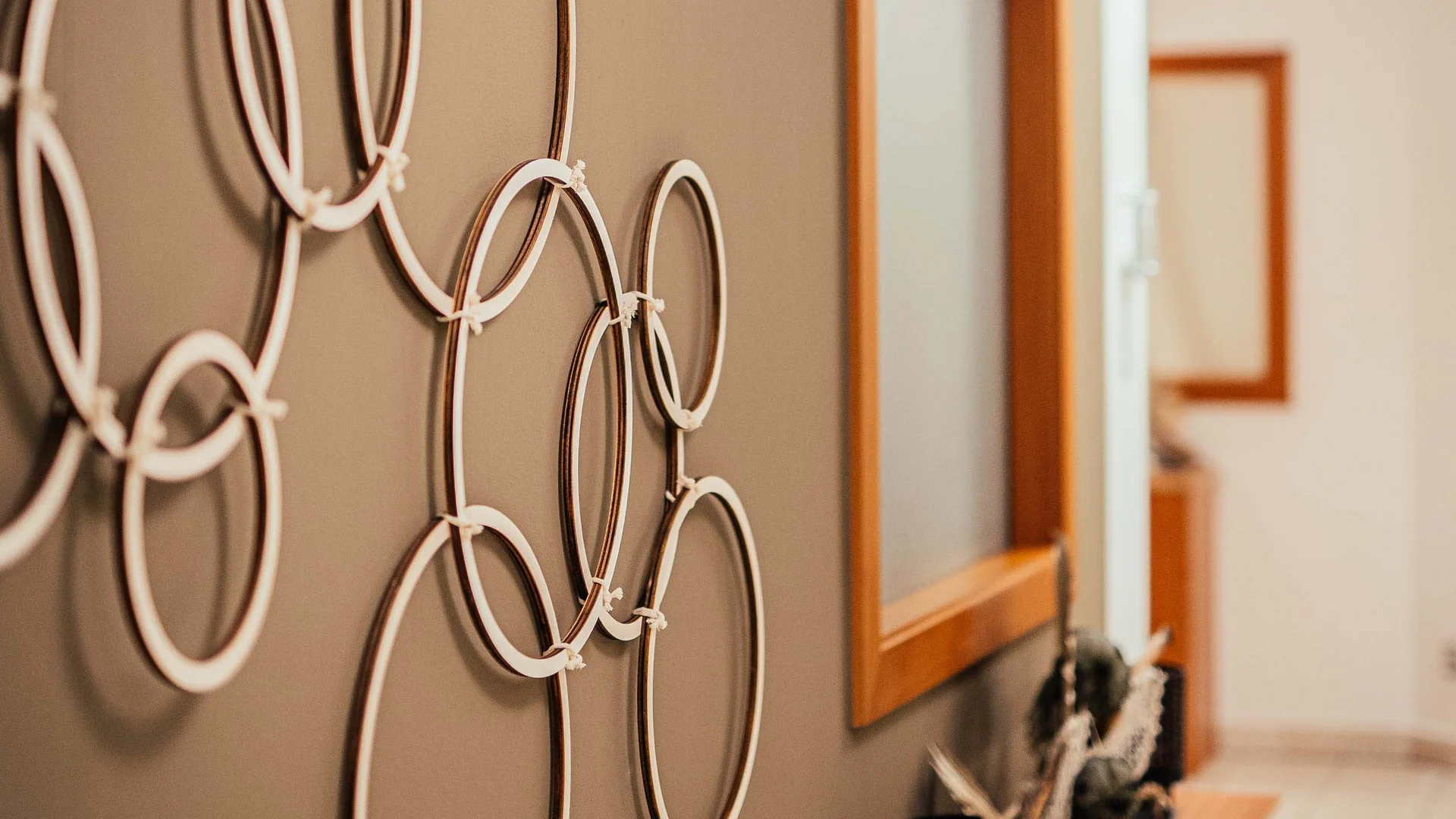 Il vostro hotel con spa vicino a Brunico Decorazione da parete moderna con anelli bianchi in un corridoio con mobili in legno