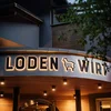 Residence Lodenwirt | Vacanza a Vandoies Beleuchtetes Schild mit LODEN WIRT und Schaf-Logo an Gebäude bei Abend