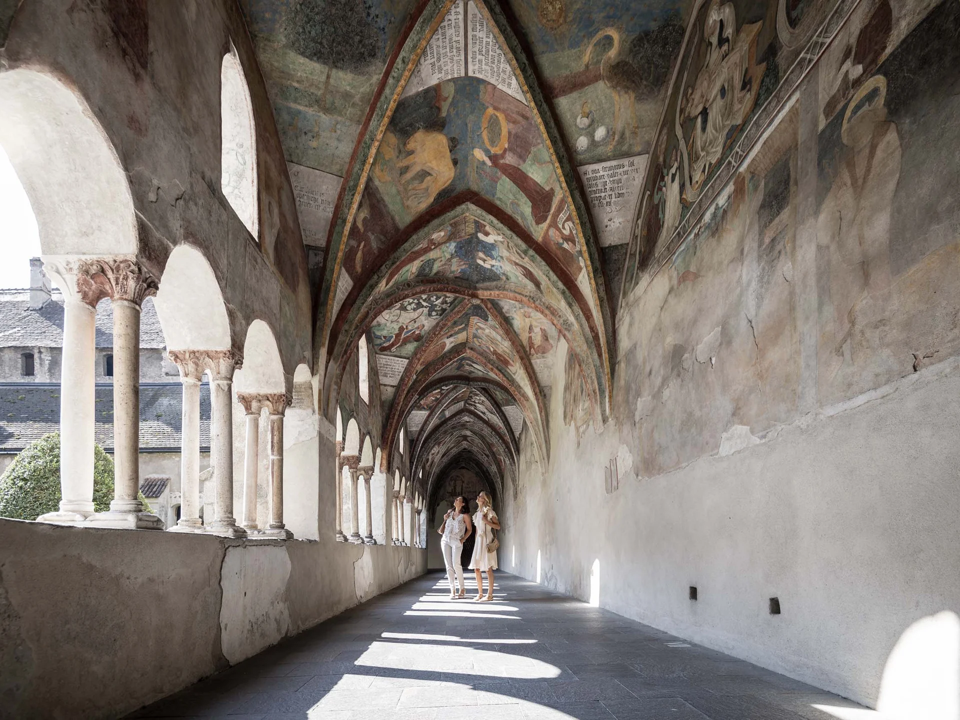 Le vostre vacanze in Val Pusteria Chiostro affrescato con colonne e due visitatrici