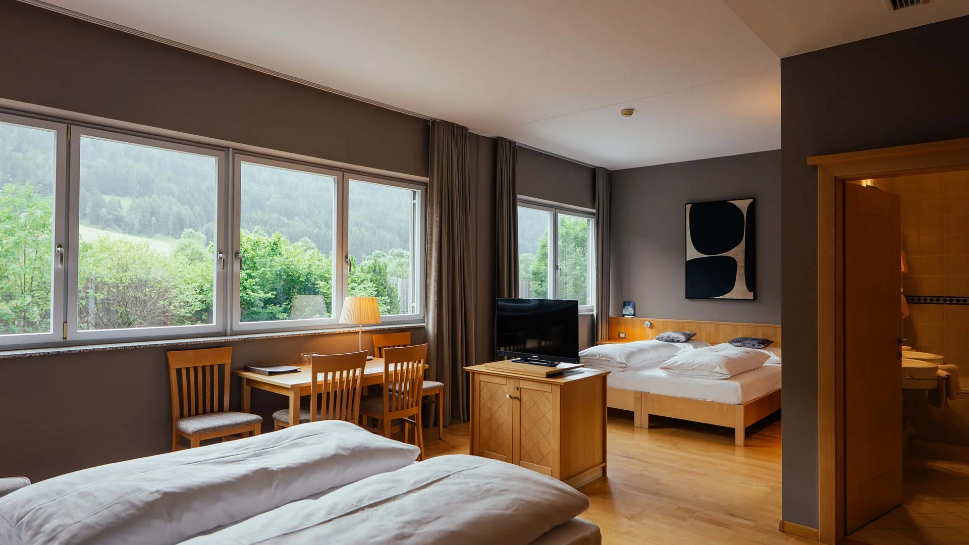 Residence Lodenwirt | Vacanza a Vandoies Camera d'hotel con due letti, tavolo, sedie e vista sulle montagne verdi