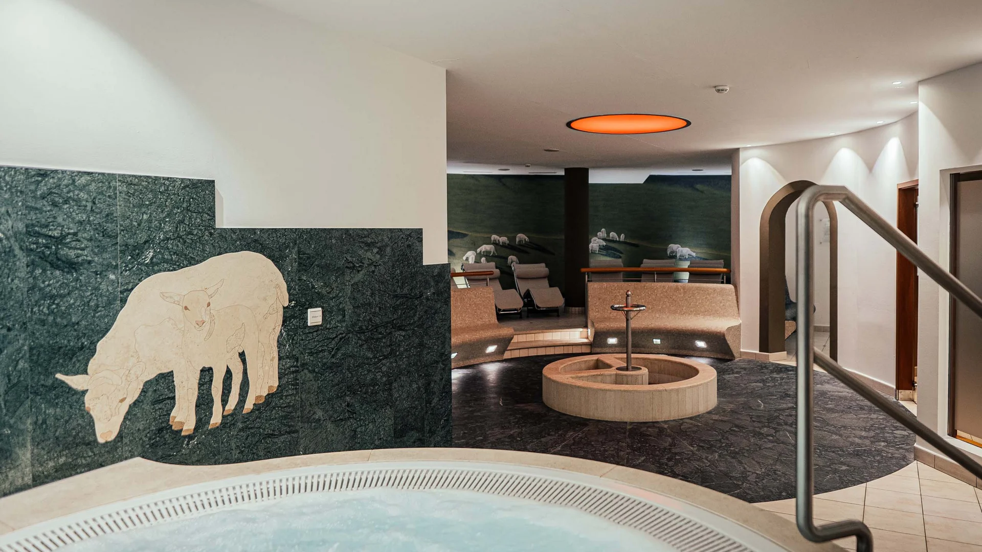 Il vostro hotel con spa vicino a Brunico Innenbereich mit Whirlpool, Sitzbereich und Schafmosaik an der Wand