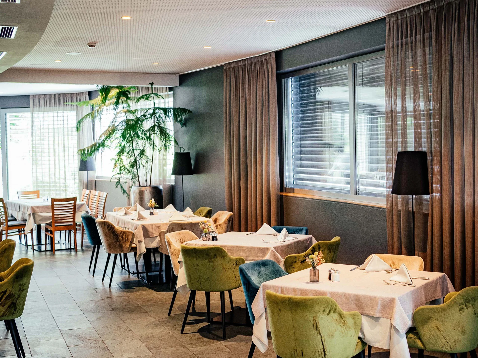 Modernes Restaurant mit gedeckten Tischen und bunten Stühlen