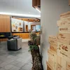 Der Lodenwirt in Vintl | Hotel, Residence & Restaurant Moderne Hotellobby mit grauen Sesseln und Holzwanddekoration