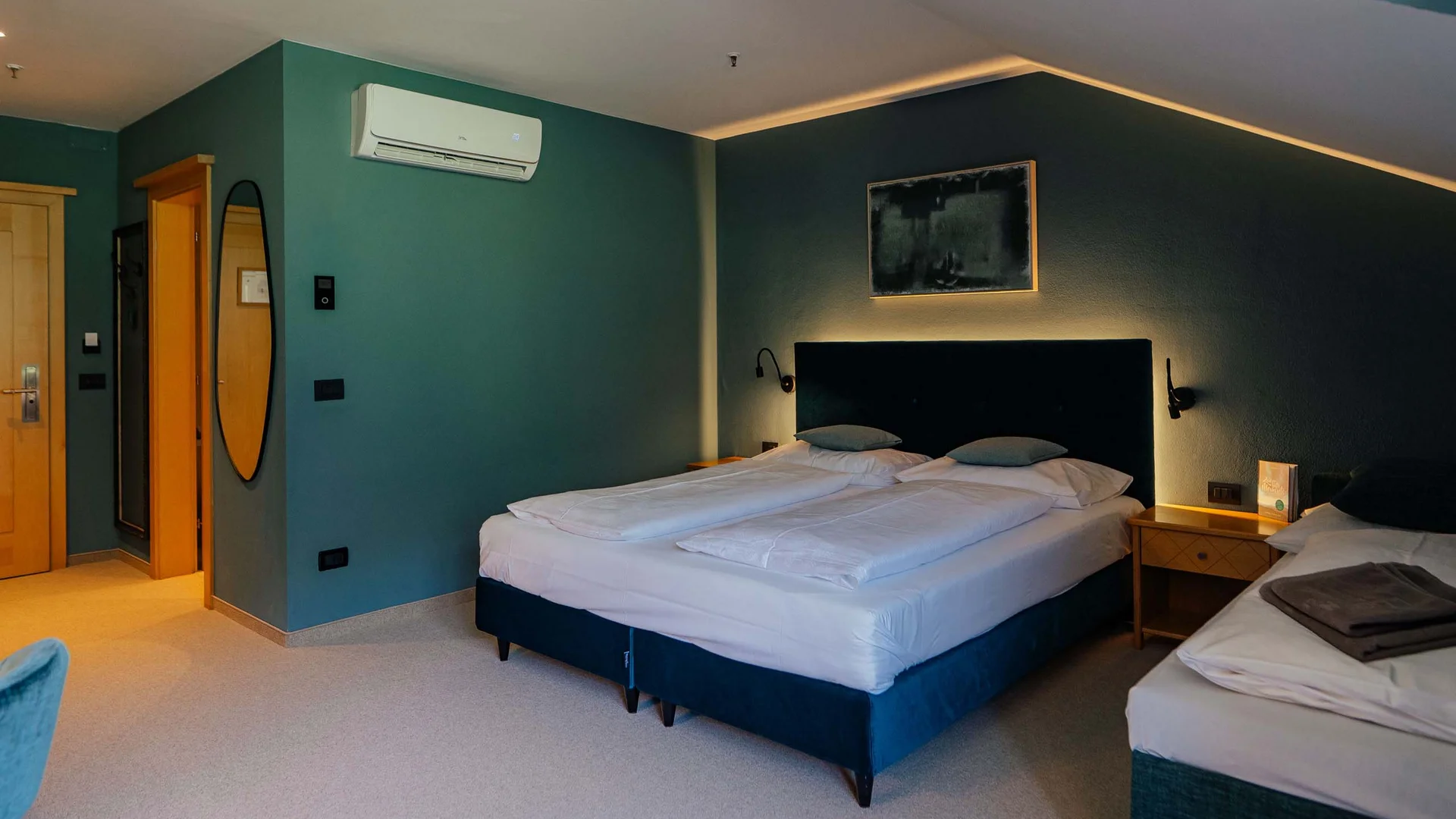 Freut euch auf dieses Hotel in Vintl. Modernes Hotelzimmer mit Doppelbett, Einzelbett und indirekter Beleuchtung