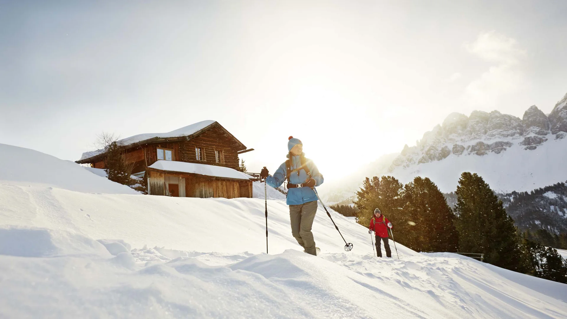Hotel & Residence Lodenwirt photo gallery Two ski tourers crossing a snowy landscape near a mountain hut