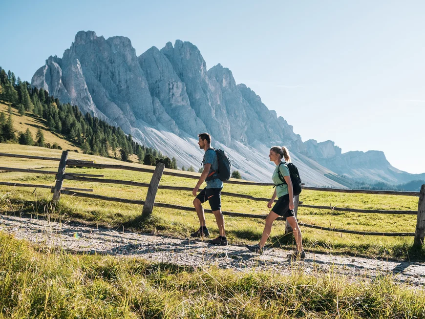 Le vostre vacanze in Val Pusteria Due escursionisti davanti a un’imponente montagna su un sentiero alpino
