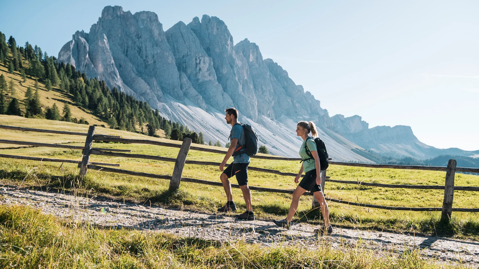 Due escursionisti davanti a un’imponente montagna su un sentiero alpino