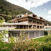 Modernes Hotelgebäude mit Balkonen in grüner Berglandschaft