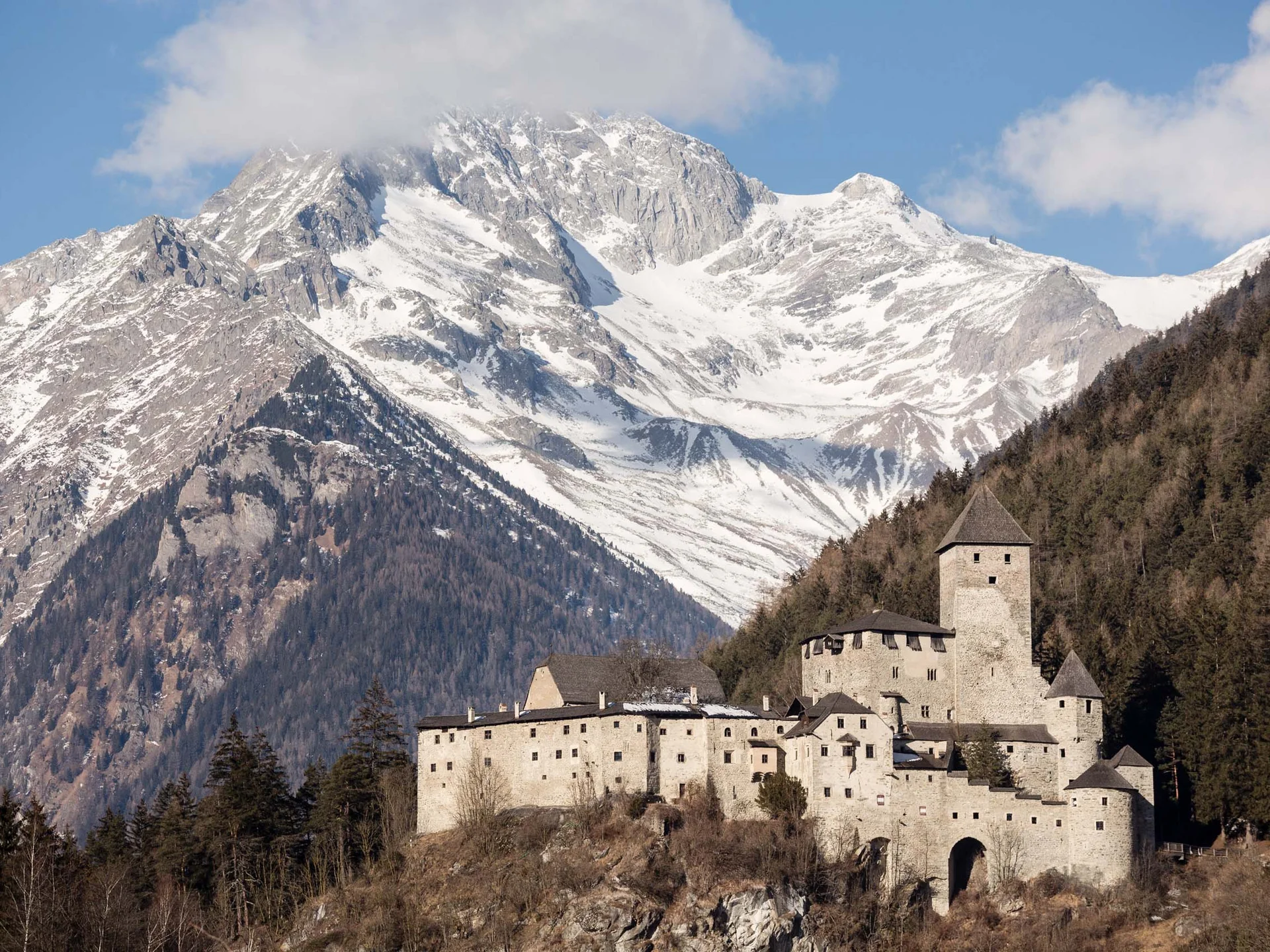Le vostre vacanze in Val Pusteria Castello medievale davanti a una montagna innevata