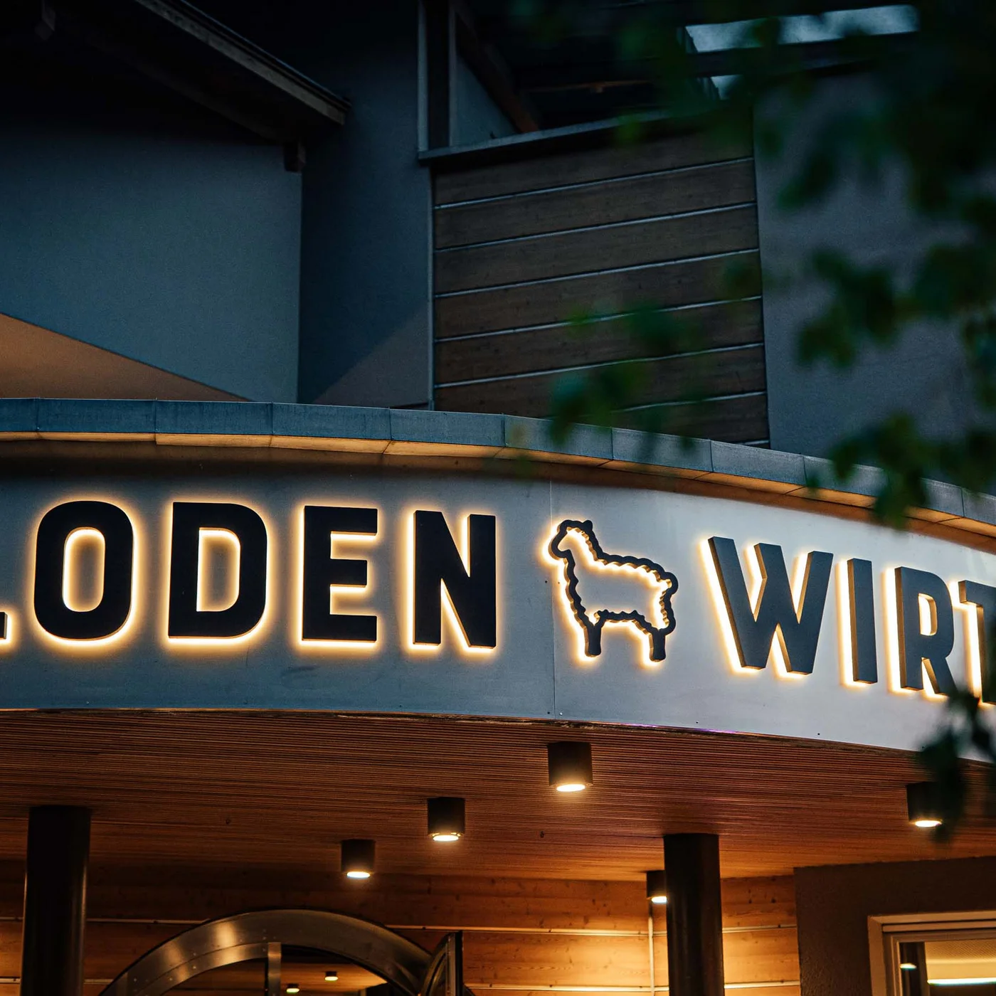 Il Lodenwirt a Vandoies | Hotel, residence e ristorante Insegna illuminata con scritta Loden Wirt e simbolo di lama