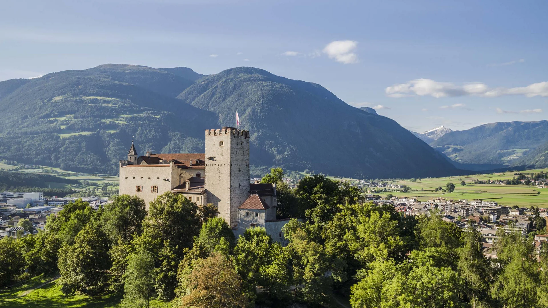 Castello con torre davanti a montagne, valle e città
