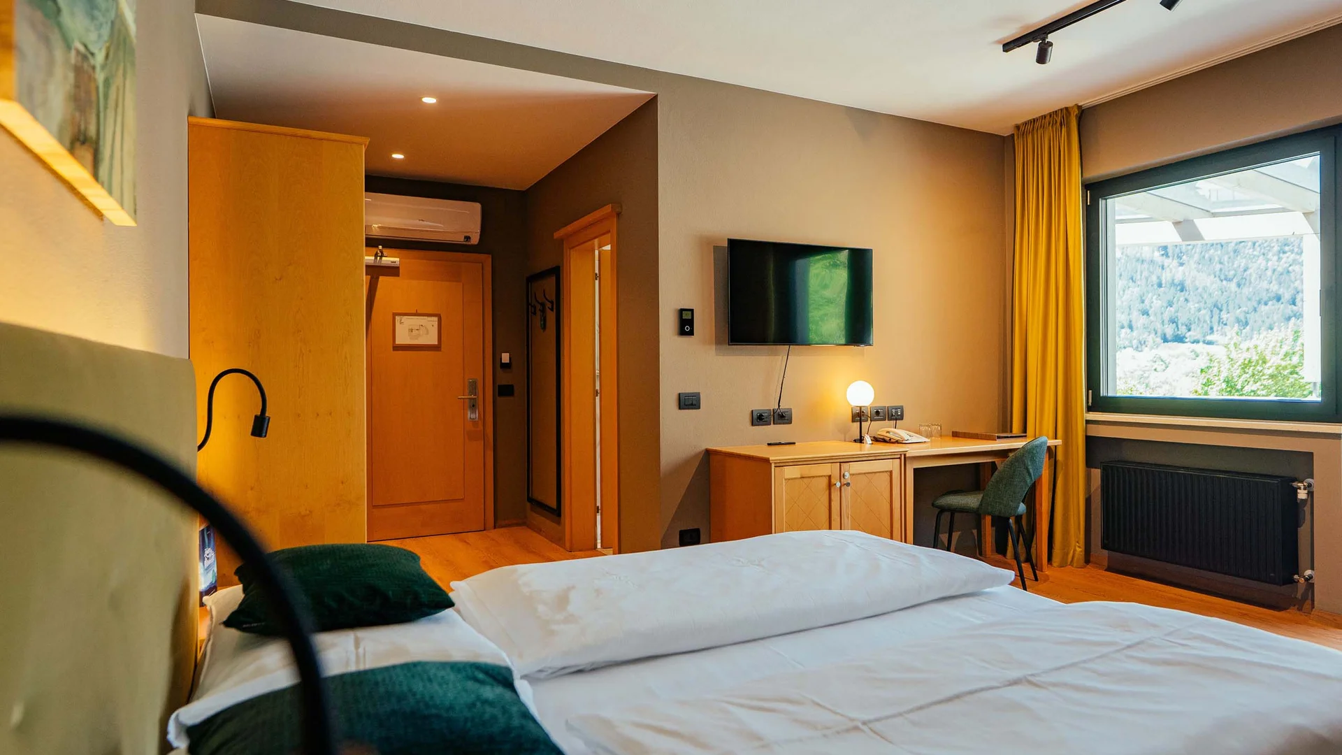 Gemütliches Hotelzimmer mit Doppelbett, Schreibtisch und Fenster mit Bergblick