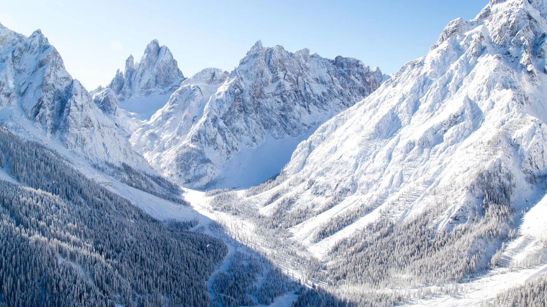 Hotel & Residence Lodenwirt photo gallery Snow-covered mountain peaks and forested valley under a blue sky