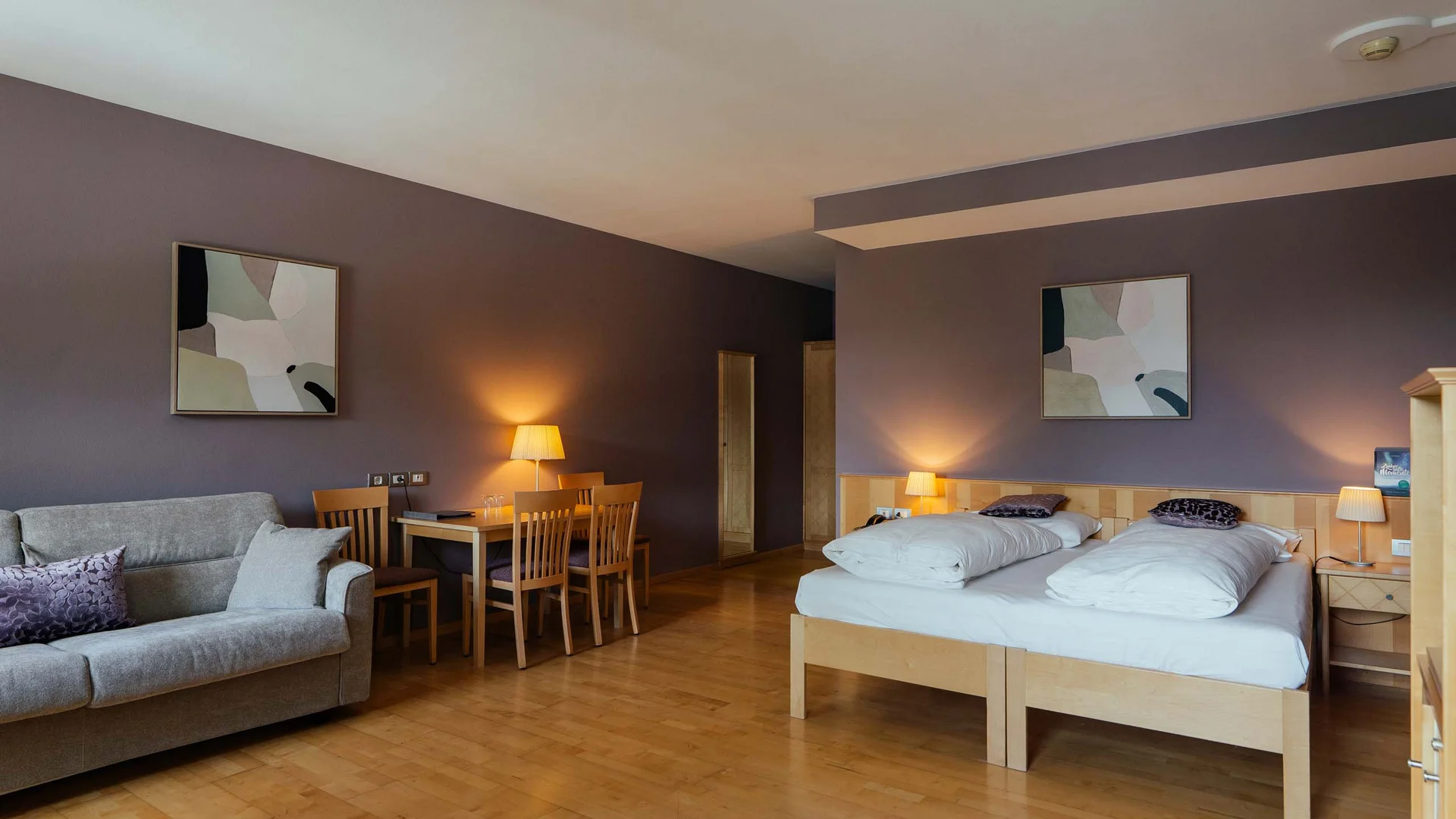 Residence Lodenwirt | Vacanza a Vandoies Camera d'hotel moderna con letto matrimoniale, divano e tavolo da pranzo