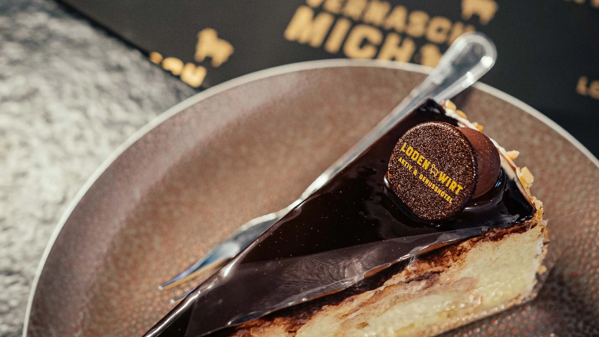 Fetta di torta con glassa al cioccolato e decorazione su piatto marrone