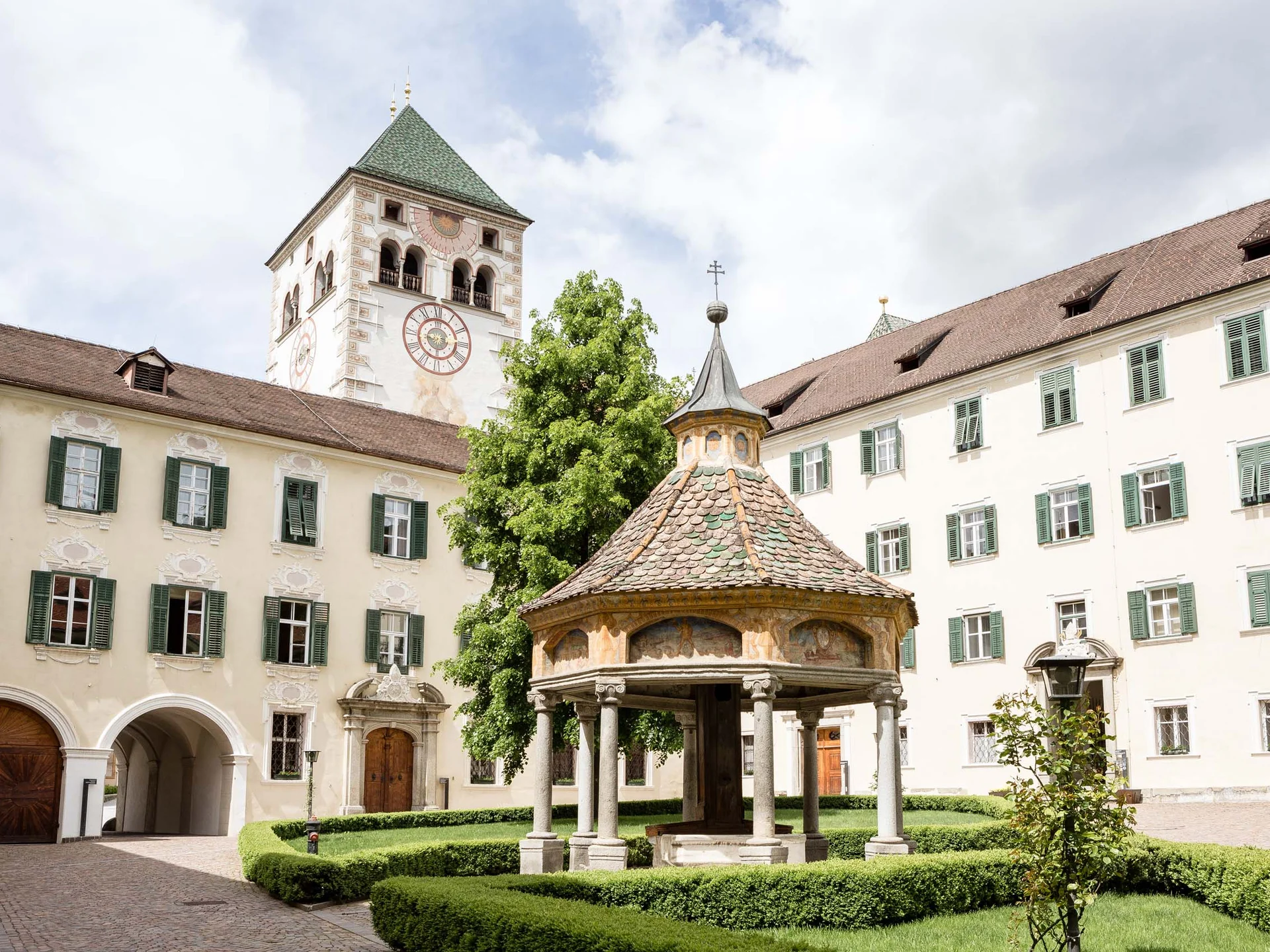 Le vostre vacanze in Val Pusteria Cortile storico con padiglione della fontana e torre dell’orologio