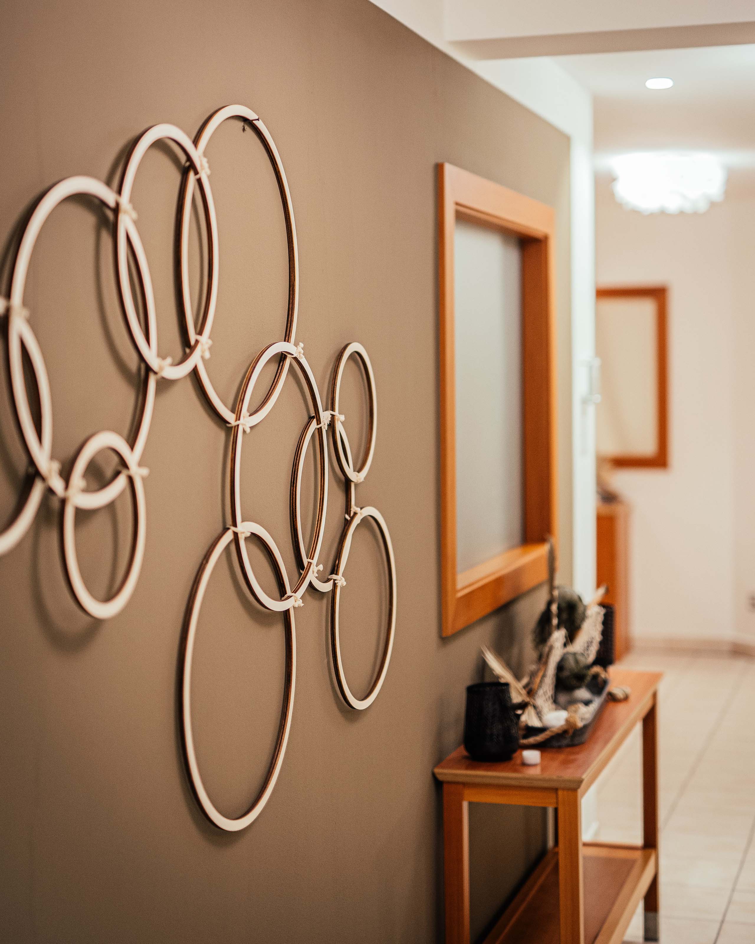 Additionals Decorazione da parete moderna con anelli bianchi in un corridoio con mobili in legno