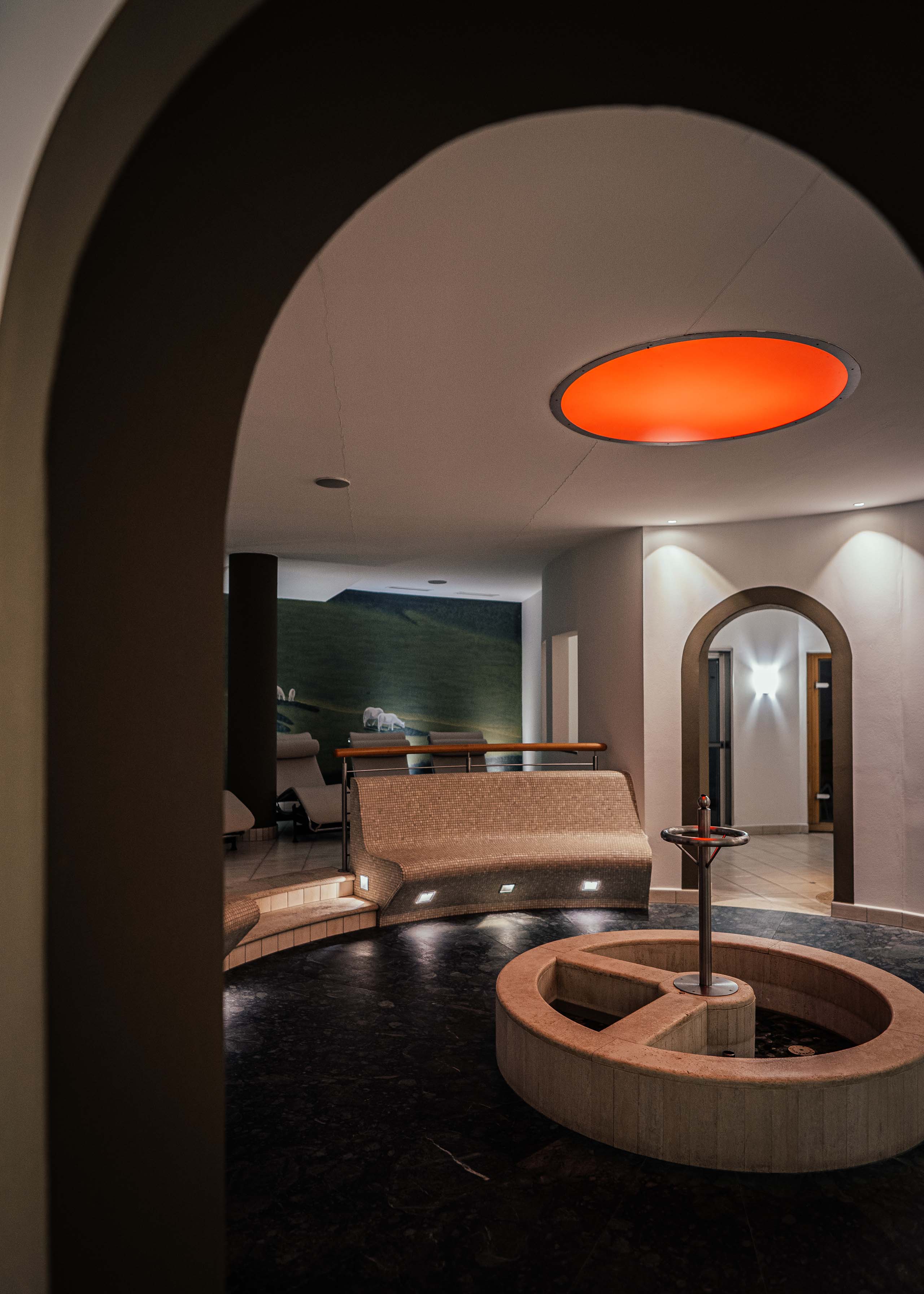 Additionals Moderner Ruheraum mit runder Sitzbank und zentralem Brunnen