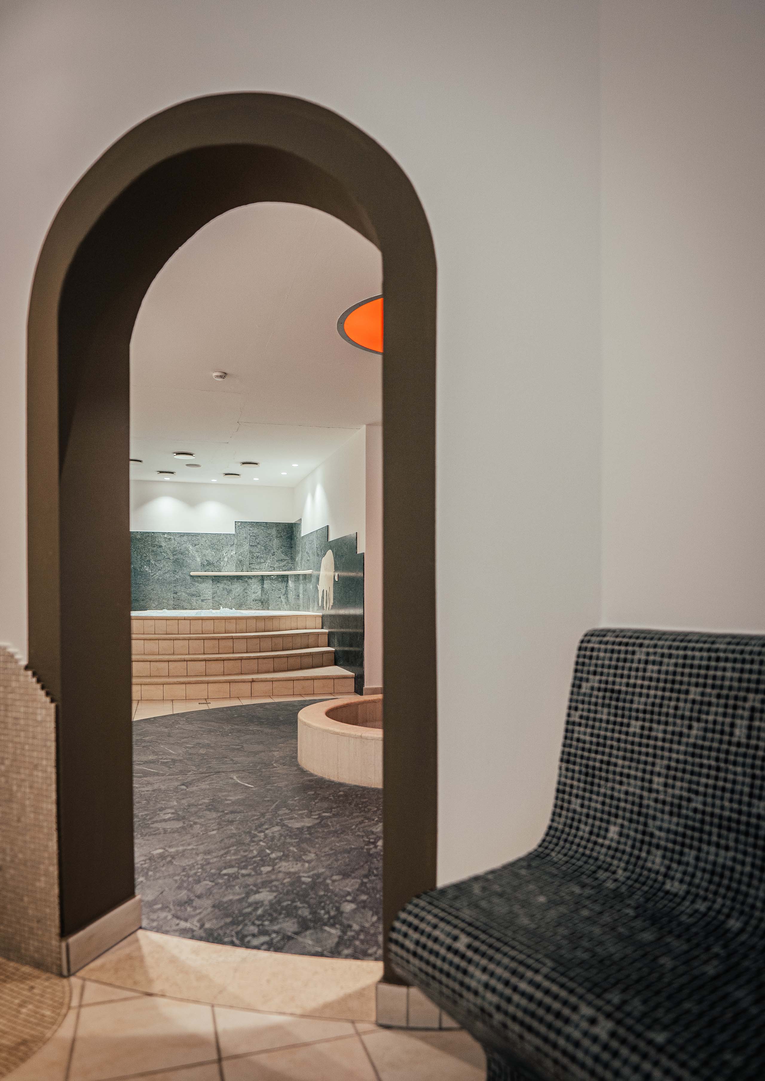 Additionals View through an archway to a spa area with steps and seating bench